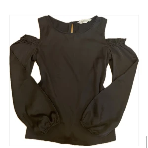 Svart off shoulder blus - Svart off shoulder blus med långa ärmar med resår vid handlederna som ger en snygg puffeffekt. Står storlek 164 och passar XS/S.