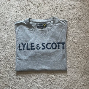 Grå Lyle & Scott t-shirt  - Skick: 8,5/10  Märke: Lyle & Scott  Storlek: 14-15 years (XS)  Färg: Grå ✅