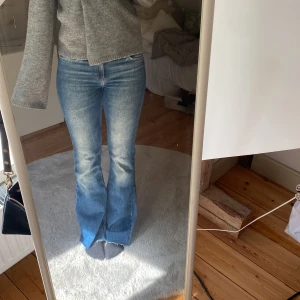 Blå bootcut jeans från Lee - Säljer ett par klassiska blå jeans från Lee med bootcut-modell och råa kanter nertill. Jeansen har normal passform, fem fickor och snygga slitningar framtill. Nya kostar jeansen 700kr. Jeansen är fåtals andvända💕
