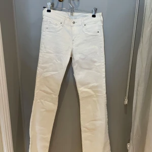Vita lågmidjade booycut jeans - H&M   - Snygga vita jeans med bootcut och lågmidjade. Byxorna har silverfärgade nitar och knapp, samt bälteshällor i midjan. Från H&M i jättebra skick! 