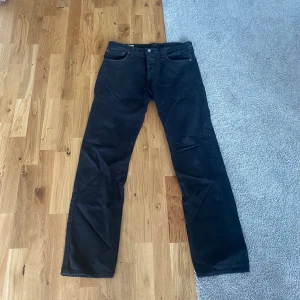 Svarta Levi's 501 Jeans 33/34 - Svarta Levi's 501 jeans med klassisk rak passform och fem fickor. Jeansen har knappgylf och den ikoniska läderpatchen bak i midjan. Snygga och tidlösa jeans i bomull som funkar till allt. Perfekt för dig som gillar en clean och enkel look. Skick 7/10.