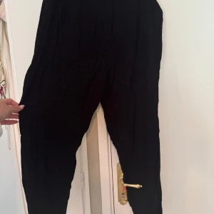 Svarta linnebyxor från ASOS Design - Svarta linnebyxor från ASOS Design i avslappnad passform. Byxorna har hög midja och raka ben, perfekta för en chill och stilren look. Tillverkade i svalt linnematerial som passar grymt under varmare dagar.