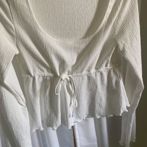 Söt vit topp - Säljer min supersöta topp från Nelly. Säljer då den inte kommit till användning och toppen är i nyskick! ☺️