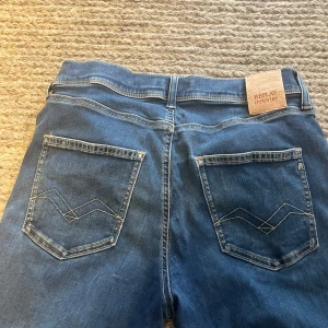 Blå Replay Hyperflex slim/skinny jeans - Säljer ett par blå Replay Hyperflex jeans med skinny/slim fit. Jeansen har klassisk femficksdesign, snygga bakfickor med broderad detalj och stretchigt material för extra komfort. Perfekta för dig som gillar en tajt och modern look.