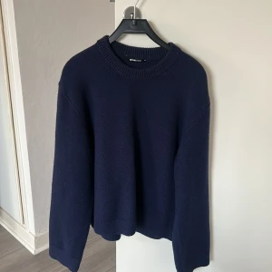 Mörkblå stickad tröja från Gina Tricot - En enkel mörkblå stickad tröja från Gina Tricot. Tröjan har rund halsringning, länga ärmar. Den är i storlek XS, den är skönt material och är perfekt till hösten och vintern!