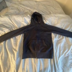 Mörkblå hoodie med dragkedja från Cubus - Mörkblå hoodie från Cubus i storlek M. Tröjan har hel dragkedja framtill, två stora fickor och en skön huva . Perfekt för chill dagar eller när du vill ha något bekvämt och enkelt. Materialet är mjukt och känns riktigt nice mot huden.