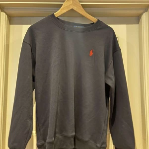 Mörkgrå sweatshirt från Polo Ralph Lauren - Snygg Ralph lauren sweatshirt i toppskick. Strl M men är liten i storleken så skulle snaraste säga S