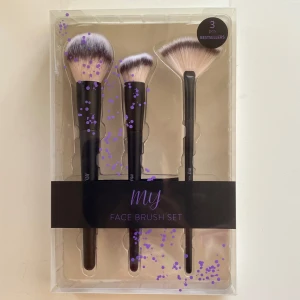 Face Brush Set med 3 borstar - Snyggt set med tre sminkborstar: en puderborste, en spiral foundationborste och en solfjäderborste. Borstarna har svarta handtag och täta, mjuka syntetstrån i vitt och brunt. Perfekt för att fixa basen och highlighta kindbenen.