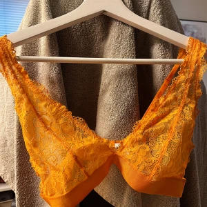 Orange spetsig bralette topp - Superfin gul bralette topp i spets från NA-KD. Tunt axelbandslös snitt och bred resår under bysten för extra support. Strl S och helt oanvänd inte ens testad 