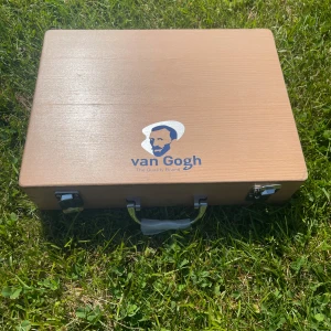 Van Gogh portfölj i trä - Snygg portfölj i ljust trä från Van Gogh, perfekt för att bära konstnärsmaterial. Väskan har metallhandtag och lås, och inuti finns flera fack för färgtuber, penslar och tillbehör. Stilren och praktisk design för dig som gillar att måla.