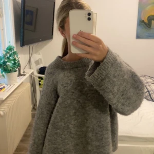 Grå stickad tröja från Gina Tricot - Säljer denna super mysiga gråa stickade tröjan som är använd få gånger men har inte kommit till användning sedan dess.
