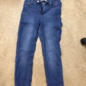 Blå jeans Molly från Gina Tricot M - Säljer ett par klassiska blå jeans från Gina Tricot, modell Molly. Jeansen har normal midja, dragkedja och knapp framtill samt femficksdesign. Materialet är stretchigt denim som sitter snyggt och bekvämt. 