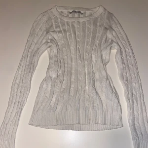 Vit kabelstickad tröja från ONLY - Säljer en vit kabelstickad tröja från ONLY i storlek S. Tröjan har rund halsringning, långa ärmar och ribbade muddar vid ärmslut och nederkant. Perfekt för lager-på-lager och en clean look.