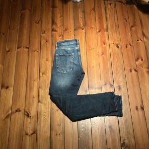 Jack&jones Tapered blå jeans Tapered/Mike - Snygga blå jeans med tapered fit från Tapered/Mike. Jeansen har klassisk femficksdesign, ljusa slitningar och kontrastsömmar. Modellen är smalare nertill och har en modern look som passar till sneakers eller boots storleken W29 L32. Skriv gärna med frågor och kan alltid pruta för ett snabbt kapp