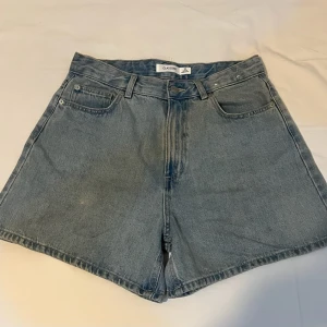 Jeansshorts - Snygga blå jeansshorts från Glassons med klassisk femficksdesign. Shortsen har en loose passform och är tillverkade i denim med bälteshällor och knappgylf. Perfekta för sommardagar och enkel att matcha med allt.