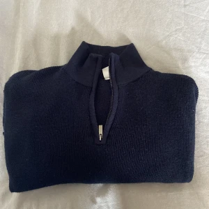 Mörkblå stickad half zip-tröja Lindex - Mörkblå stickad tröja från Lindex med half zip och hög krage. Perfekt för lager-på-lager och chill dagar. Klassisk modell med lång ärm och ribbade muddar. Enkel att matcha med jeans eller mjukisbyxor. Str: 146-152, skick: 9/10, kontakta vid frågor!
