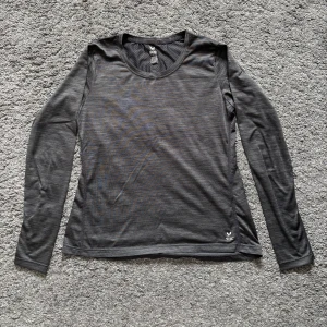 Svart långärmad träningströja SOC - Svart långärmad träningströja från SOC i lätt och stretchigt syntetmaterial. Tröjan har rund halsringning och diskret reflexdetalj på ryggen. Perfekt för löpning eller gym. Snygg och enkel design som passar till allt.