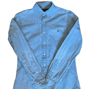 Ralph Lauren Denimskjorta - Klassisk ljusblå skjorta från  Ralph Lauren i slim fit. Storlek S, kan passa M och S. Tveka inte vid frågor eller prisförslag ⭐️