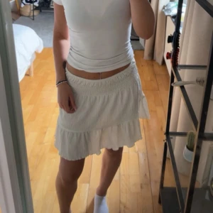 Vit volangkjol med resårmidja - Denna användes mycket förra sommaren. Den har några få små fläckar som knappt syns.