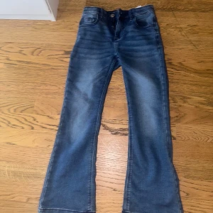 Blå kick flare jeans Bailey stl 158 Cubus - Snygga blå jeans från Cubus i modellen Kick Flare. Jeansen har klassisk femficksdesign, dragkedja och knapp framtill samt utsvängda ben. Perfekta för dig som gillar en trendig och avslappnad look. 
