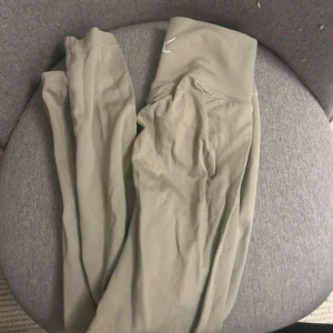 X shapes Off white /Beige leggings scrunch  - Snygga beige leggings med bred, ribbad hög midja och diskret broderad logga framtill. Stretchigt och mjukt material, samt scrunch söm i bak som framhäver ben och rumpa på ett smickrande sätt. Säljer då jag har för mycket träningskläder, de är endast använda 2-3 gånger så i fint skick 🩷