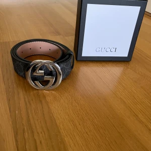 Svart bälte med silvrig logga  - Ny med box och kvitto