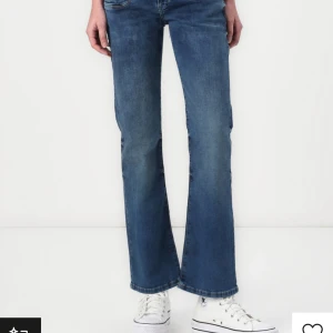 Blå valerie ltb jeans  - Snygga blå jeans med bootcut passform och klassisk femficksdesign. Jeansen har en medelhög midja och är tillverkade i slitstarkt denim. Perfekta för dig som gillar en tidlös look med lite utsvängda ben. De har lite slitningar längst ned på byxorna men det tänker man inte på när man har på sig dem.