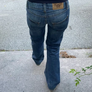 bootcut/raka jeans med slitningar - Snygga blå bootcut/raka jeans från EDC by esprit med låg midja och slitna detaljer på benet och knät. Midjemått 37 cm och innerbenslängd 80