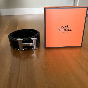 Svart bälte med silvrig logga - Helt ny med box