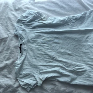 Vit basic t-shirt från Zara - Enkel och stilren vit t-shirt från Zara i mjuk bomull. Klassisk rund halsringning och korta ärmar, perfekt till jeans eller kjol. Snygg att bära både instoppad eller lös för en avslappnad vibe.