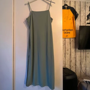 Grön klänning H&M - En rak grön klänning med en slits på höger sida anvönd 2 gånger så i mycket fint skick