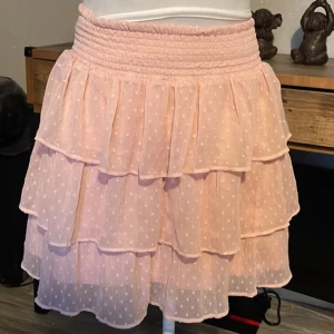 Volangkjol  - Supersöt ljusrosa kortkjol med prickar, med bred resår i midjan för skön passform 💗