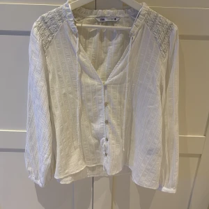 Vit blus med knappar från Zara - Supersöt vit blus från Zara med subtila glittriga ränder och snygga knappar framtill, använd ett par gånger bara💞