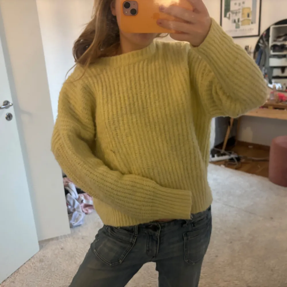 Säljer en mysig gul stickad tröja med ribbad struktur. Tröjan har långa ärmar och en avslappnad passform som är perfekt för kyligare dagar. Passar bra till jeans eller kjol för en avslappnad look. Perfekt för höst och vinter!. Neuletakit & Villapaidat.