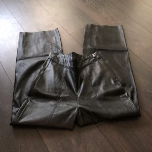 Svarta skinnbyxor från Gina Tricot - Snygga svarta skinnbyxor från Gina Tricot med dragkedja på sidan. De är högmidjade och har en rak passform. Använda en gång ute på klubben ☺️