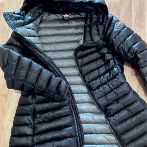 Svart dunjacka från Colmar - Snygg svart dunjacka från Colmar med quiltad design och dragkedja. Jackan har en huva och långa ärmar, perfekt för kyliga dagar. Den är stilren och funktionell, idealisk för både stad och natur.