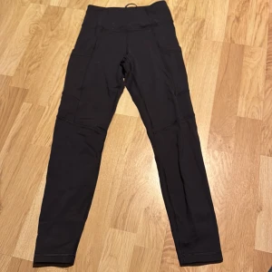 Svarta träningsleggings från SOC - Snygga svarta träningsleggings från SOC med hög midja och praktiska sidofickor. Perfekta för träning med en tight passform som ger bra stöd. Tillverkade i ett stretchigt och bekvämt material. Sällan använda