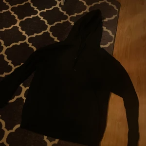 Svart hoodie från Night Addict - Säljer en svart hoodie från Night Addict med tryck på baksidan. Tröjan har en klassisk design med huva och långa ärmar. Perfekt för en avslappnad stil. Köpt på zalando för ungefär ett halvår sedan!