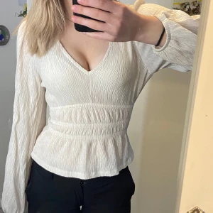 Vit v-ringad blus - Vit blus med v-ringning och långa ärmar. Blusen har en smickrande passform med lätt rynkade detaljer som ger en fin struktur. Perfekt för att klä upp eller ner beroende på tillfälle🤍