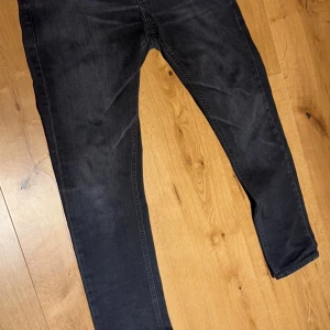 Svarta jeansbyxor från Dondup - Snygga svarta jeansbyxor från Dondup Byxorna har en slim passform (RITCHIE) Jag har valt att sälja dessa då det inte passar längre för att jag har växt ur de. Byxorna har används måttligt och har inga defekter. Storlek: längd 30 midja 34                                          skick 8/10