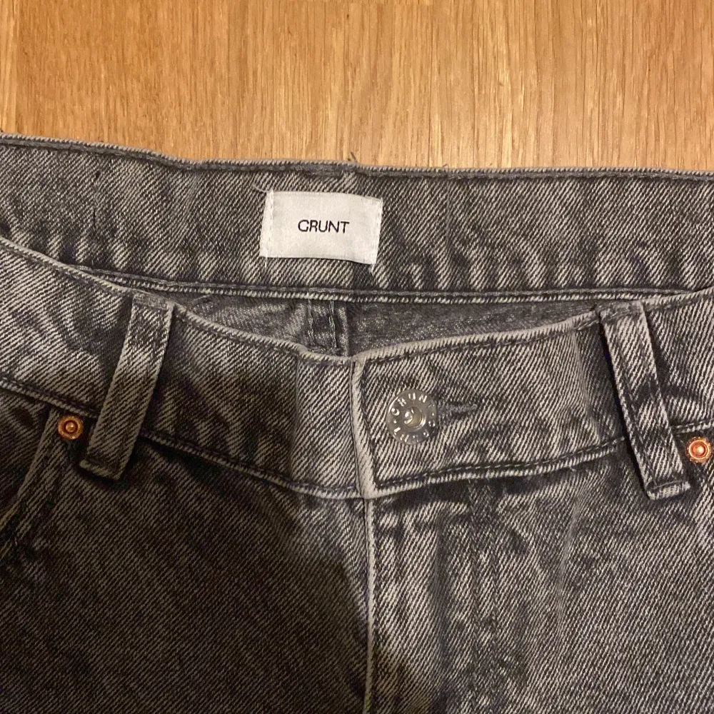 Snygga grå jeans från Grunt med klassisk femficksdesign. De har en avslappnad passform och är perfekta för en chill stil. Jeansen har en knappgylf och bälteshällor för extra stilpoäng. Dom är bara använda en gång! Byxorna passar dig som är runt 170cm. Säljer dom för att dom inte är min stil. Nypris på dom är 599kr. Farkut & Housut.