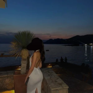 Klänning öppen rygg - Elegant vit klänning med en tight passform, ryggen är öppen samt slits baktill, perfekt inför fest eller sommar