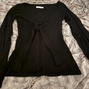Design by si tröja  - Snygg svart långärmad topp från Design by Si med knytning framtill. Storlek Xs/S nästan helt oanvänd kostar egentligen 450