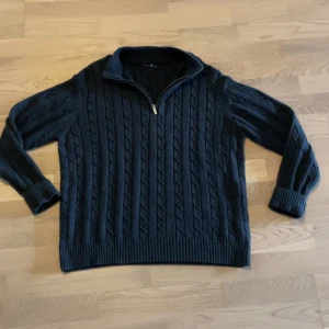 Mörkgrå/svart stickad tröja -  kabelstickad tröja från i storlek L passar dessutom M. Tröjan är i mycket bra skick