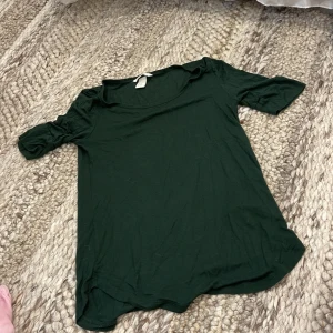 Mörkgrön topp från H&M Basic XS - Enkel mörkgrön topp från H&M Basic i storlek XS. Modellen har rund halsringning och korta ärmar