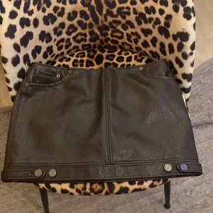 Brun läder kjol - Snygg mörk brun kort kjol i skinnimitation från H&M. Helt oanvänd med lappen kvar.
