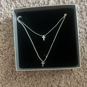 Silverfärgat halsband med kors - Snyggt dubbelt halsband med två kors! Detta är helt nytt och aldrig använt. Anledningen till att jag säljer är för att den inte används. Ny pris är 400