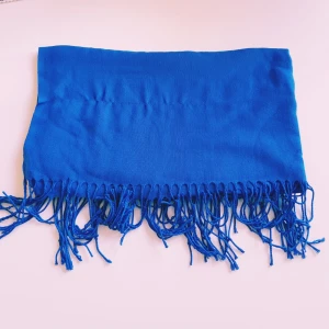 Kornblå halsduk med fransar - En stilren kornblå halsduk med långa fransar i ändarna. Halsduken är mjuk och lätt, perfekt att slänga över axlarna för en färgklick. Enkel design utan mönster, passar dig som gillar att sticka ut med färg.  Helt skick dock noppror