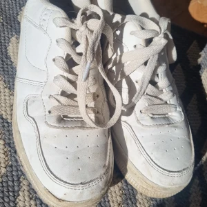 Vita sneakers från 157, storlek 37 - Klassiska vita sneakers från 157 med snörning och rund tå. Skorna har en platt sula och är tillverkade i syntetmaterial med textilfoder. Perfekta för en clean och enkel stil.