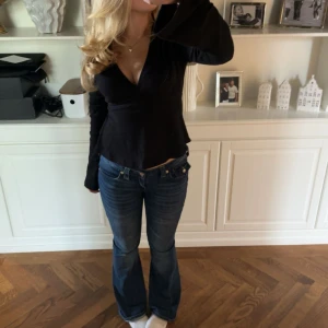 True Religion lågmidjade bootcut jeans - Säljer ett par ikoniska blå jeans från True Religion med låg midja och bootcut passform. Jeansen har klassiska kontrastsömmar, snygga detaljer på bakfickorna har vita detaljer. Säljer för att inte kommer till användning jätte bra skick derför högt pris